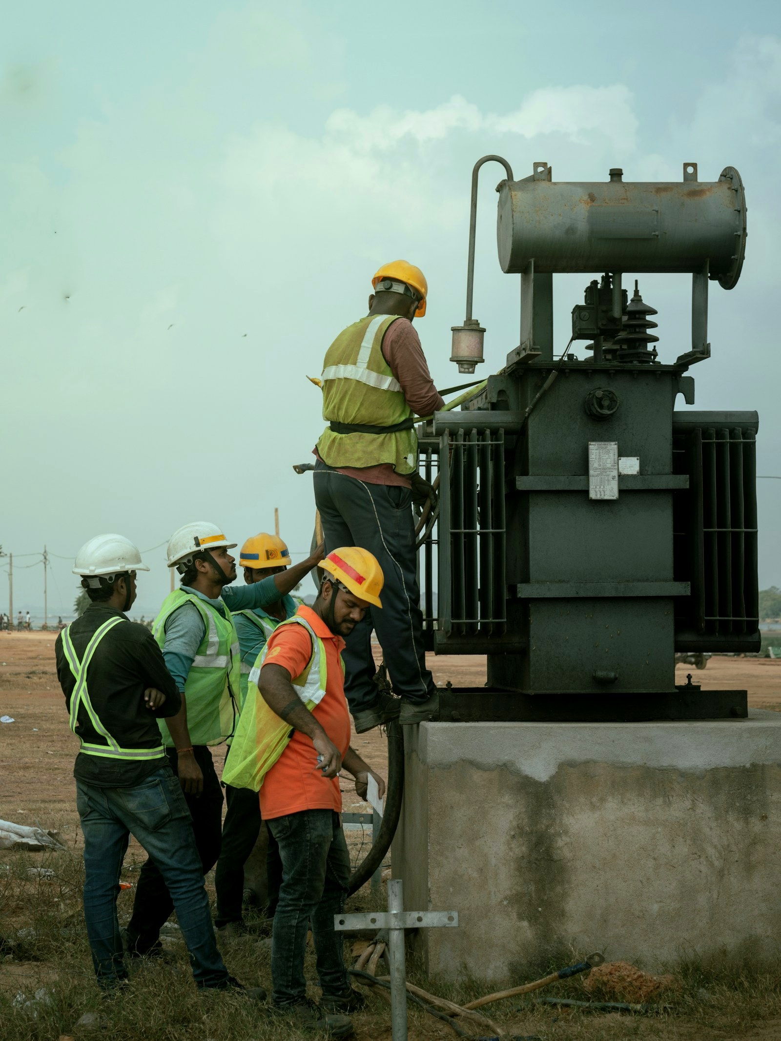 Engineer servicing a power transformer during a maintenance visit