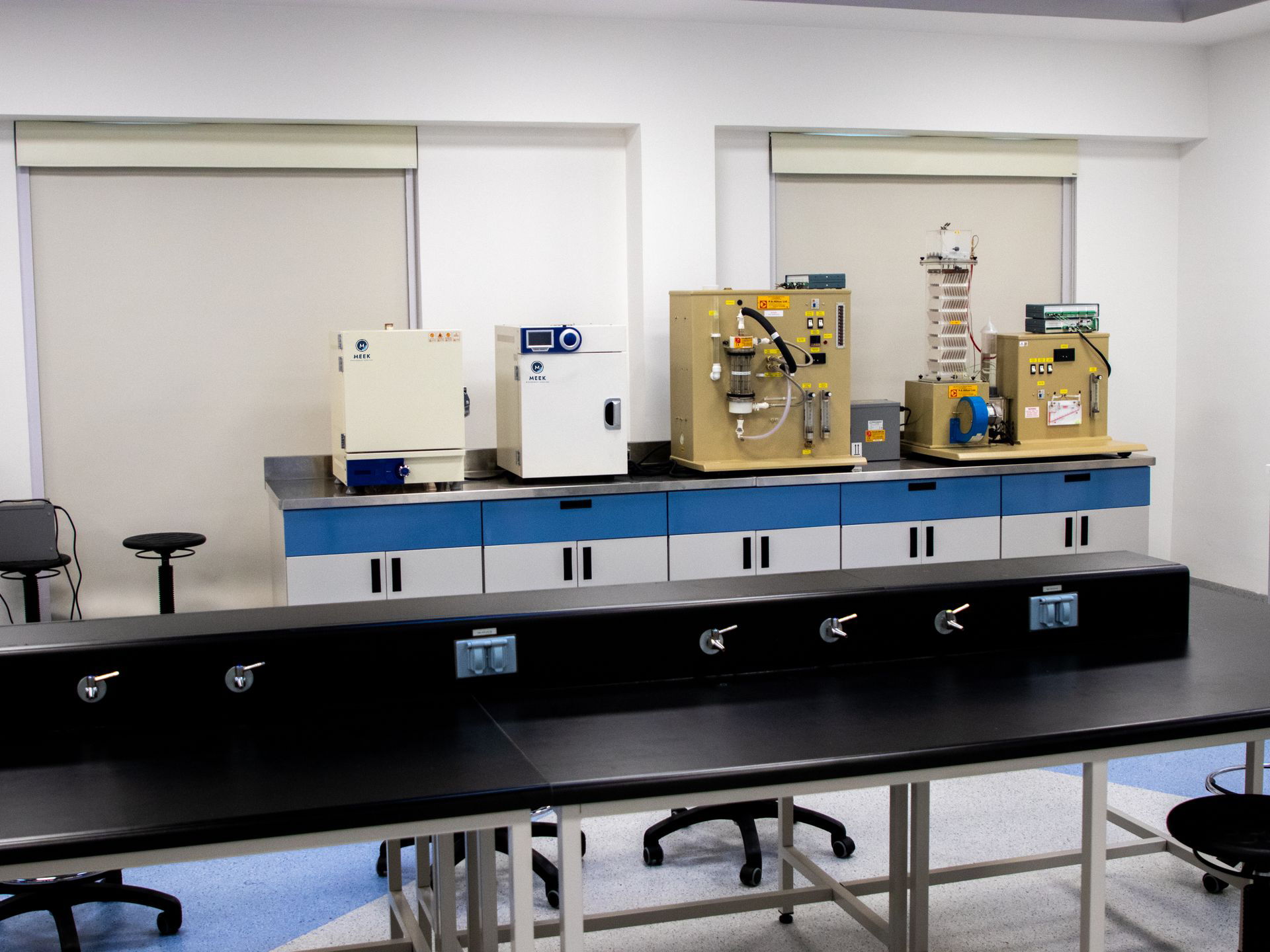 Testing laboratory with bench-mounted ovens, instrument rigs and blue cabinetry