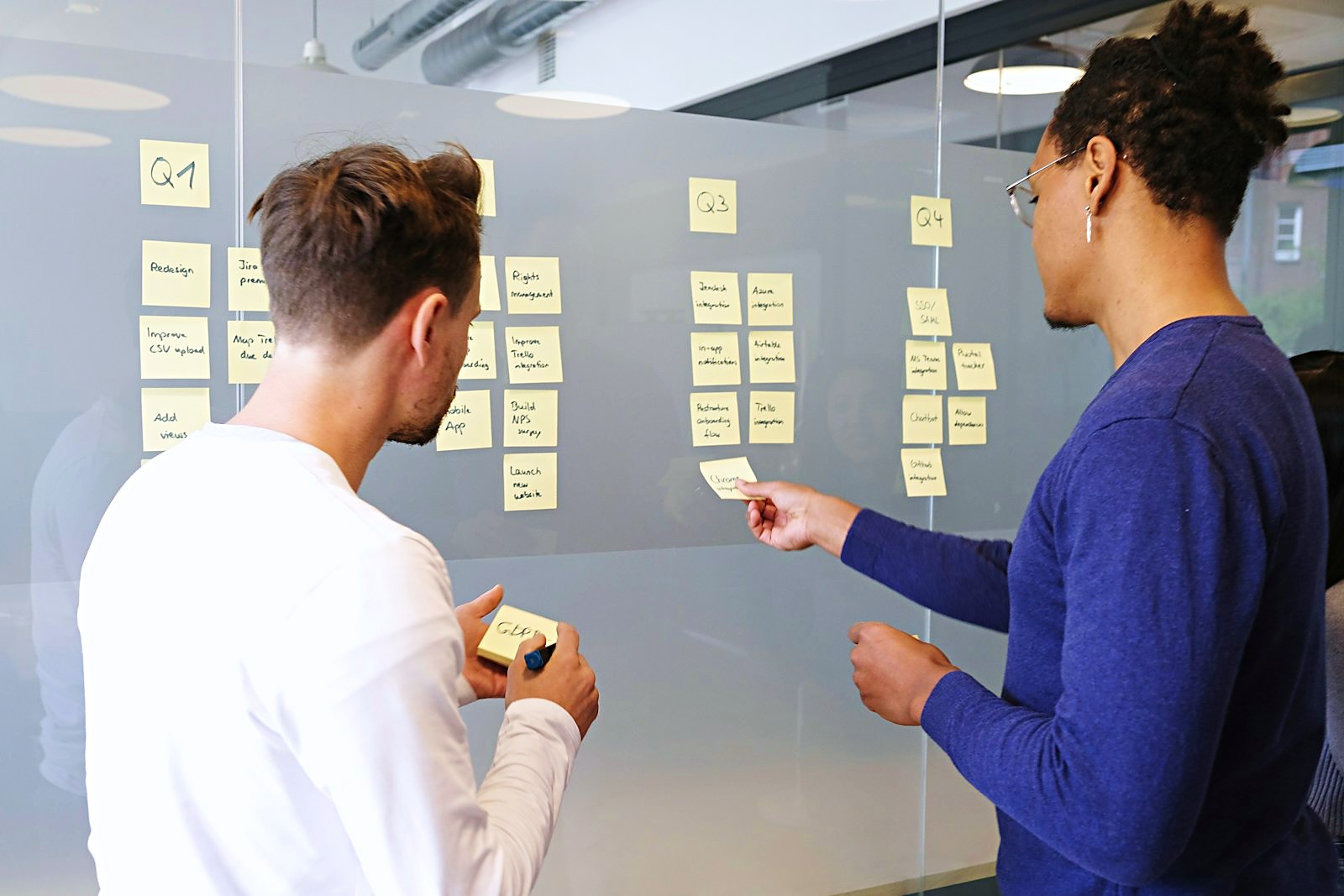 Quarterly roadmap board mapped out on a glass wall with sticky notes