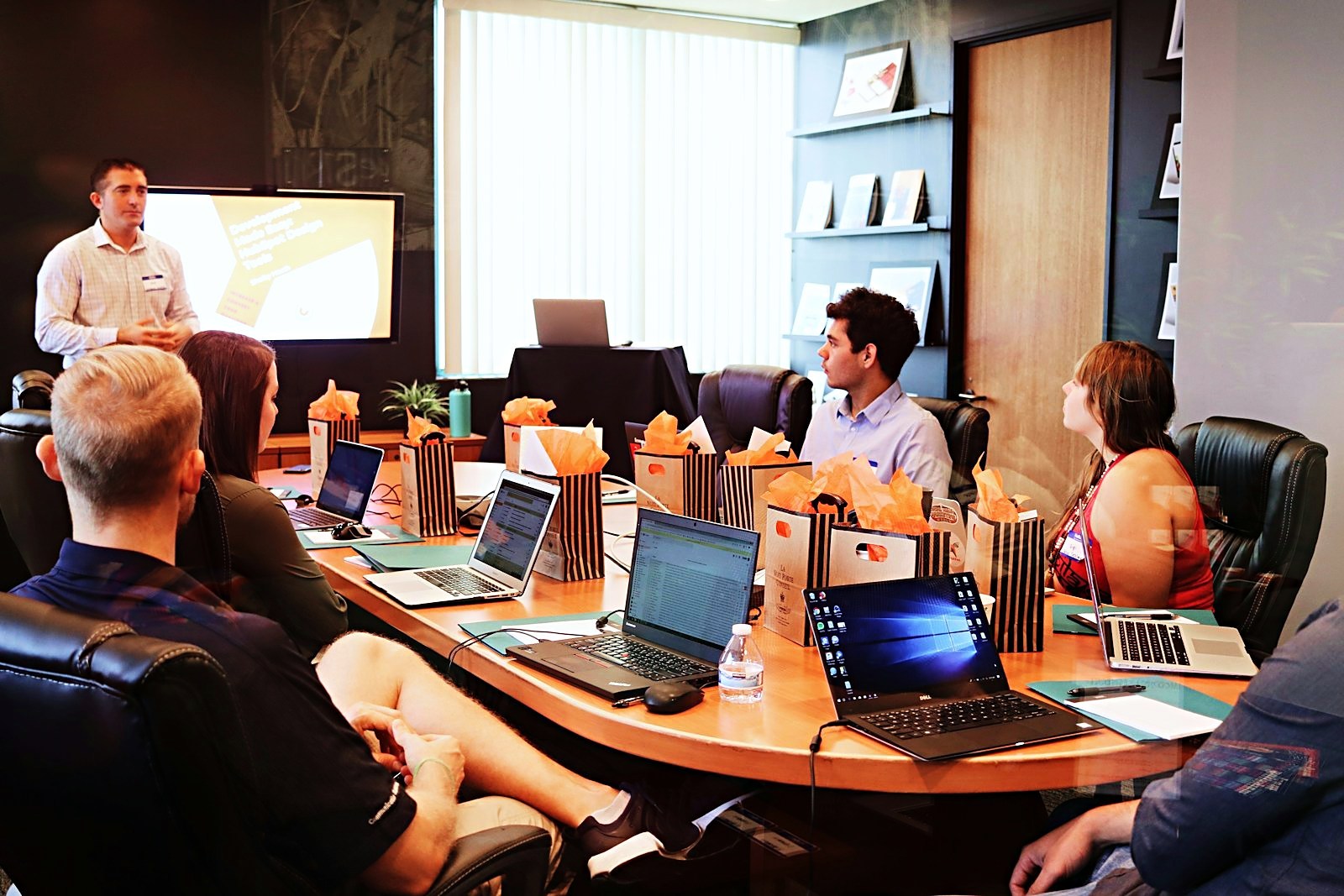 Facilitator presenting to a seated group in a boardroom training session